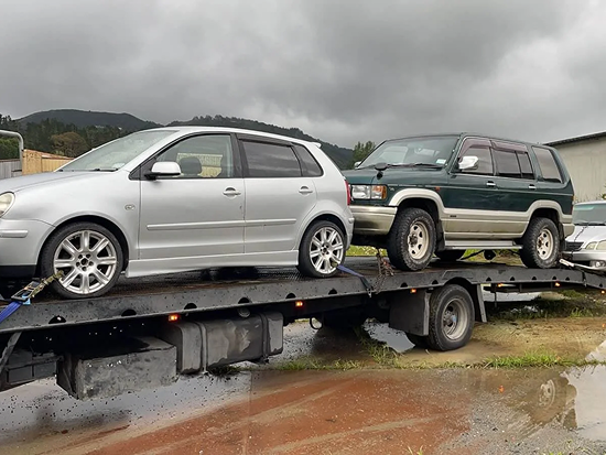 Tow truck in Rotorua carrying two scrap cars for removal and recycling